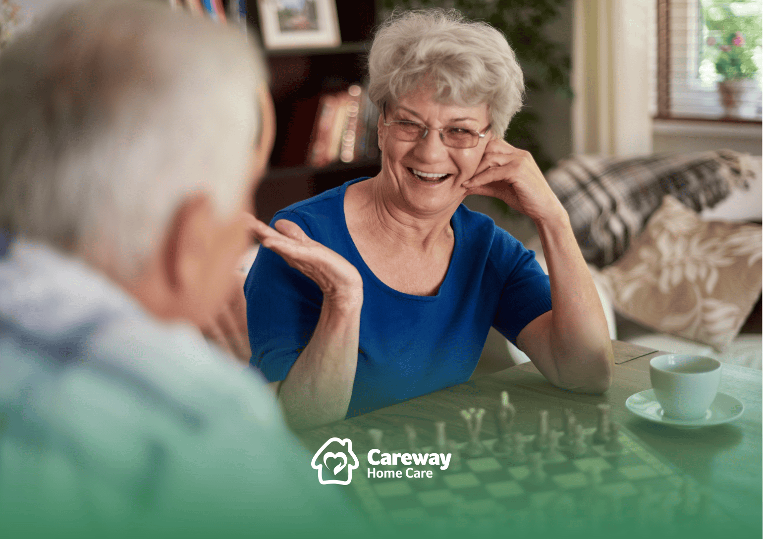 Two seniors playing a game of chess in a living room